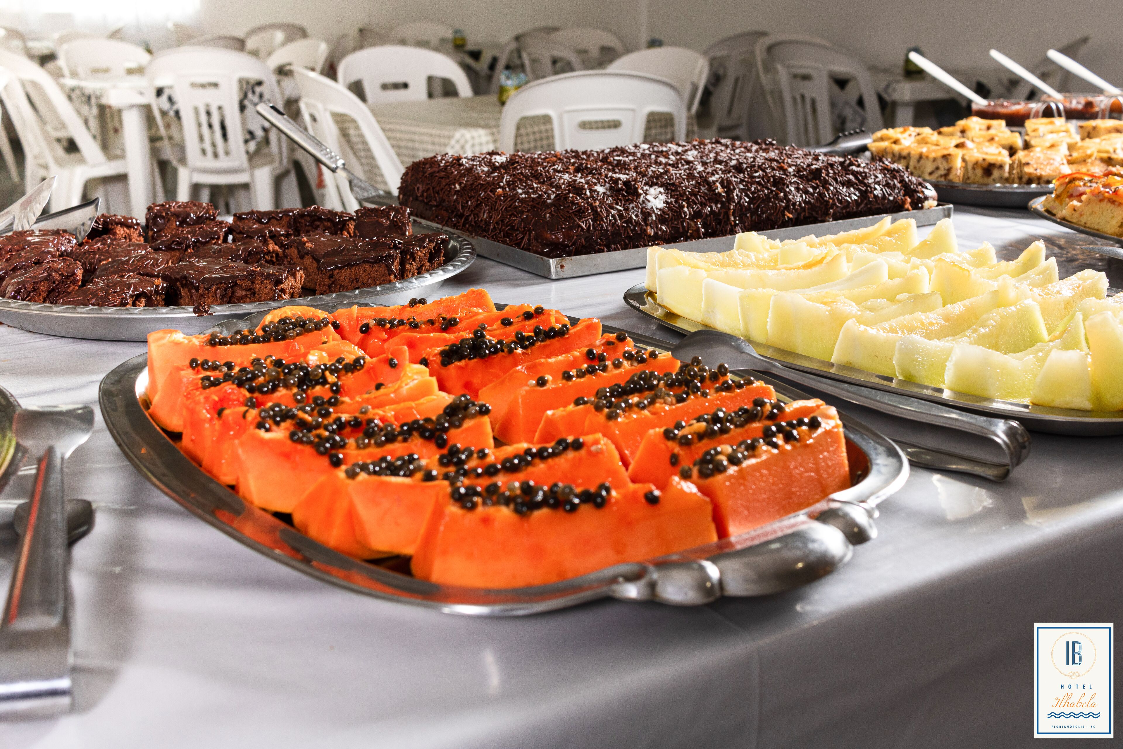 A buffet table with various desserts and fruits.