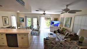 A spacious living area with a kitchen, dining table, and a comfortable sofa.
