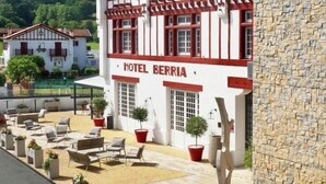 Un hotel in stile architettonico europeo tradizionale, con un balcone e una facciata in pietra.