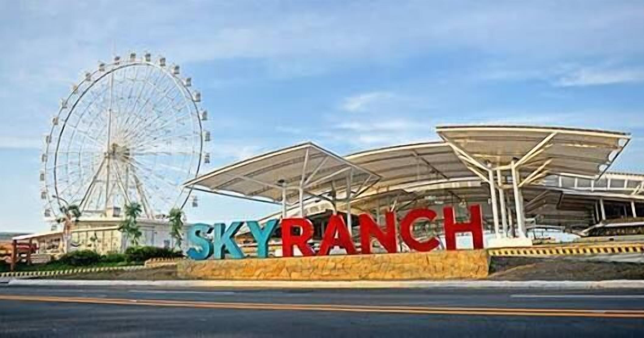A large Ferris wheel and a building with a sign that reads "SKY RANCH".