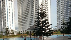 A swimming pool area with multiple high-rise buildings in the background.