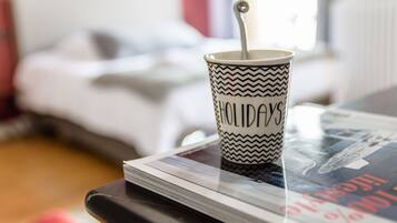 A cup with the word "HOLIDAYS" on it, placed on a table with a magazine.