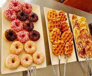 A variety of donuts and waffles on trays. - Hotel Augusta (Gabicce Mare)