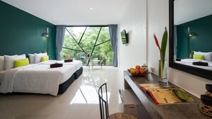 Een moderne hotelkamer met een groot bed, een bureau en uitzicht op groen buiten het raam.