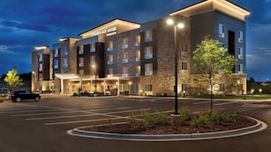 A multi-story hotel with a stone facade, multiple balconies, and a well-lit entrance.