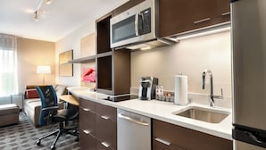 A modern kitchen with a microwave, coffee maker, and refrigerator.