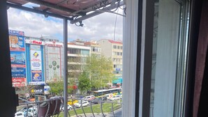 A balcony with a view of a busy street, a metal railing, and a door to the right. - Bufes Hotel (Istanbul)