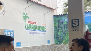 A restaurant with a pool view, a sign for 'Residencial Marina House', and a fire extinguisher on the wall. - Residencial Marina House (La Banda de Shilcayo)