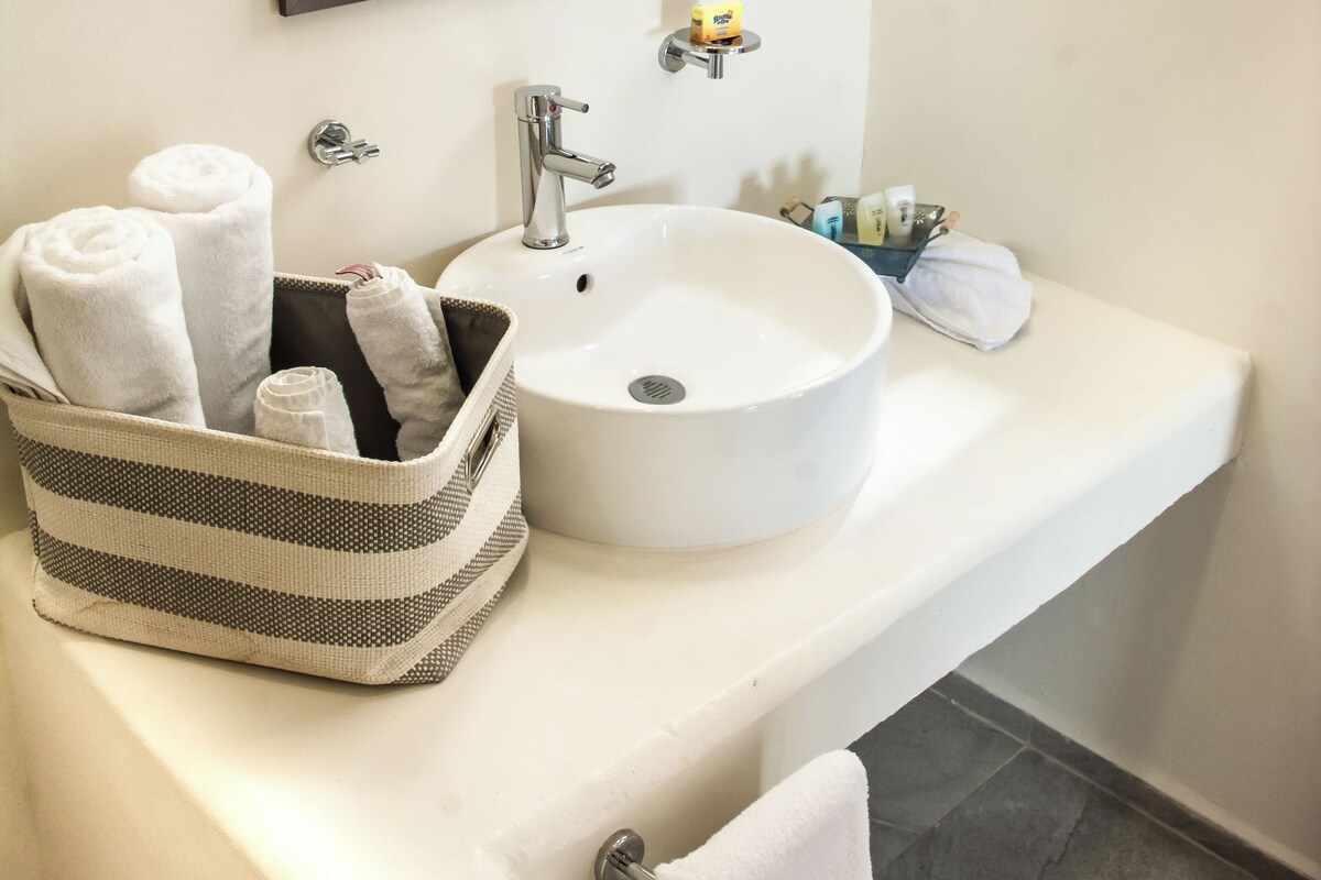 A bathroom with a white sink, a mirror, and a towel rack.