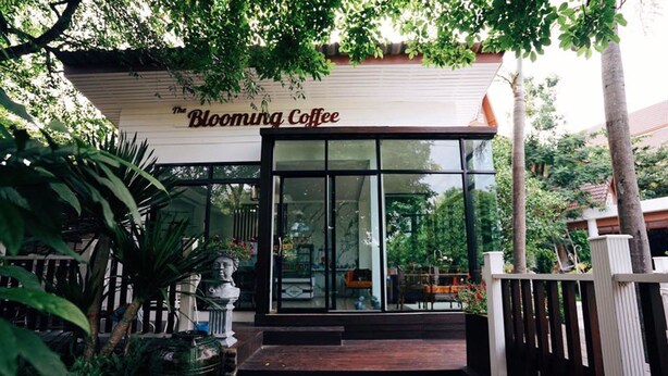 A coffee shop named "The Blooming Coffee" with a wooden exterior and glass doors. - Wangyao Riverside Resort (Nakhon Nayok)