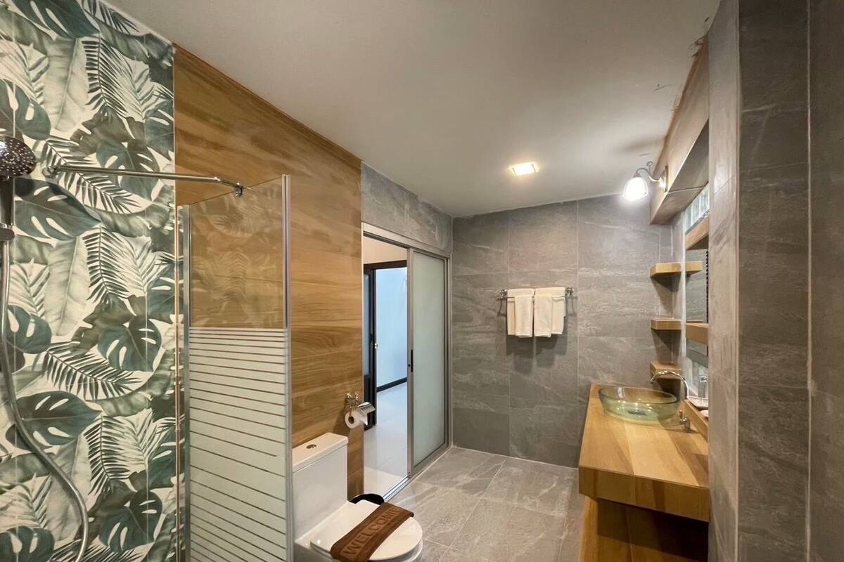 A modern bathroom with a shower, toilet, and vanity.
