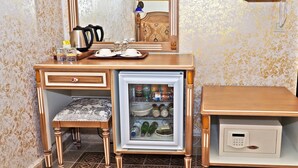 A compact hotel room with a vanity area, a small refrigerator, a bedside table, and a mirror. - Sirkeci Gar Hotel (Istanbul)
