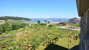 A balcony with a view of a vineyard, a playground, and a marina. - Hotel Maracaibo (Sanxenxo)