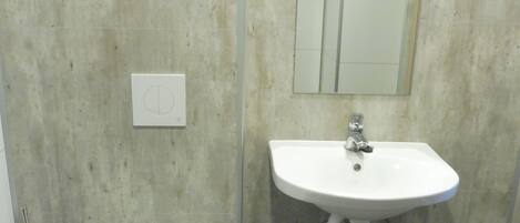Un bagno con il water, un lavandino e uno specchio.
