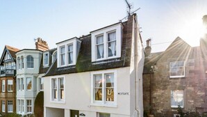 A two-story building with a white facade, multiple windows, and a sign reading "WESTGATE". - Southcot (North Berwick)