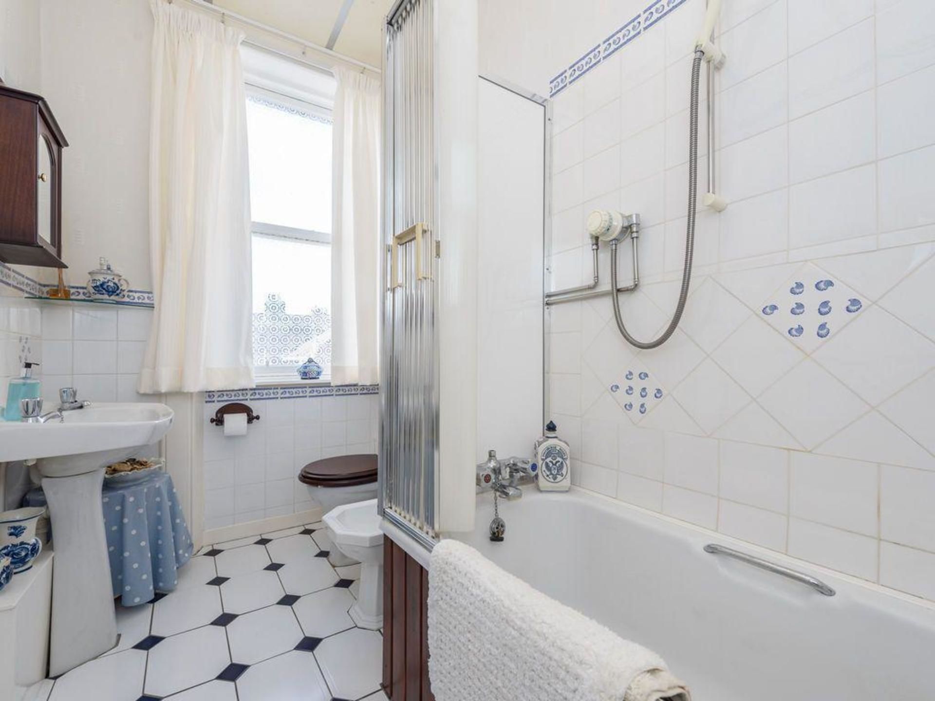 A bathroom with a bathtub, a shower, a toilet, and a sink.