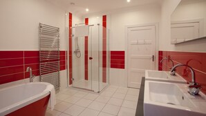 A modern bathroom with a glass-enclosed shower, a freestanding bathtub, and a vanity with dual sinks. - Cherry Blossom Cottage (Cupar)