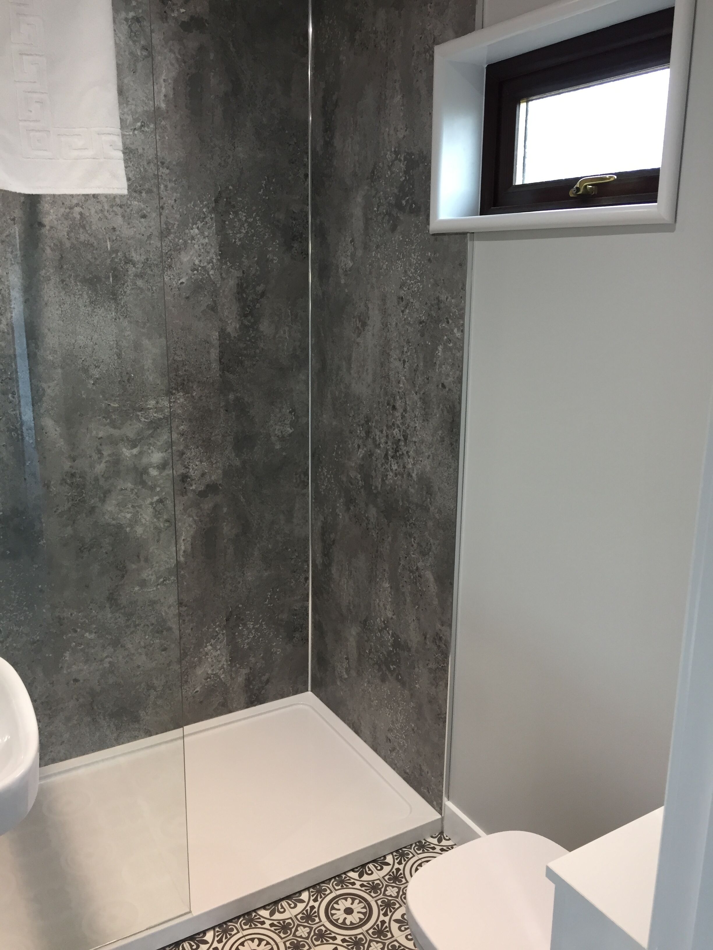 A bathroom with a shower, a toilet, and a sink.