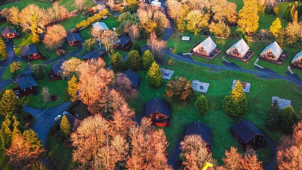 An aerial view of a residential area with multiple houses, roads, and trees.