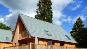 A wooden cabin with a sloped roof, a fenced deck, and a clear sky. - Lord Galloway 32 (H 2016) 82334 (Newton Stewart)