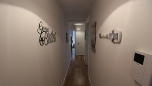 A hallway with a sign reading "Gone to the Beach" and a thermostat on the wall. - Flat 8 Palm Court (Bournemouth)