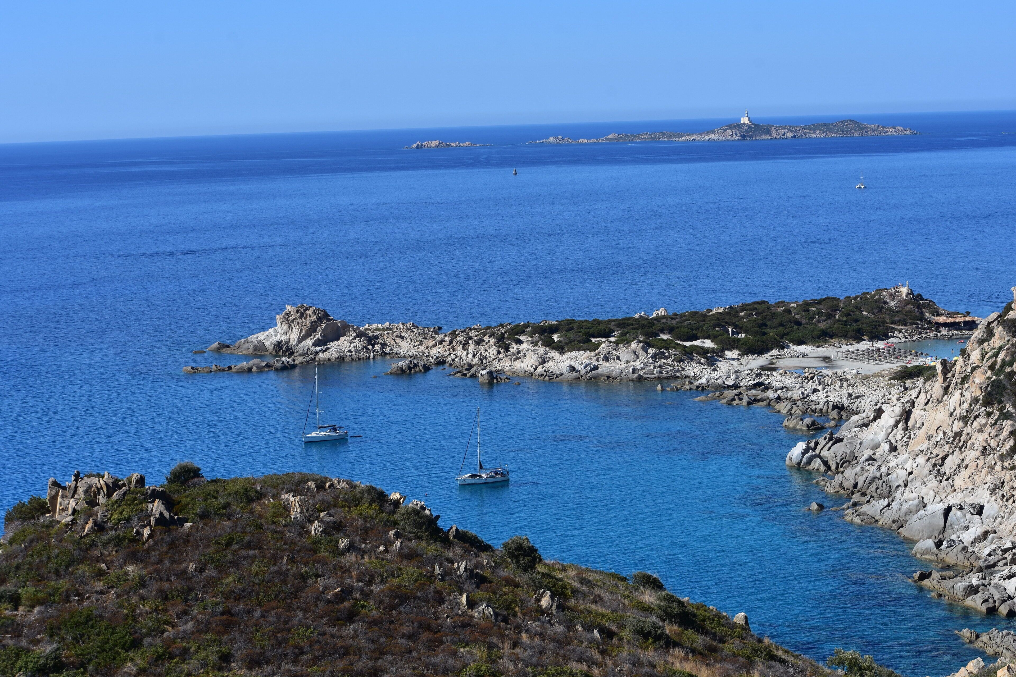 Un paysage côtier caractérisé par un terrain rocheux et des eaux d’un bleu limpide.