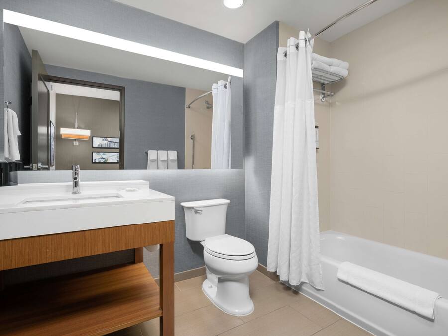 Een moderne badkamer met een wastafel, toilet en bad.