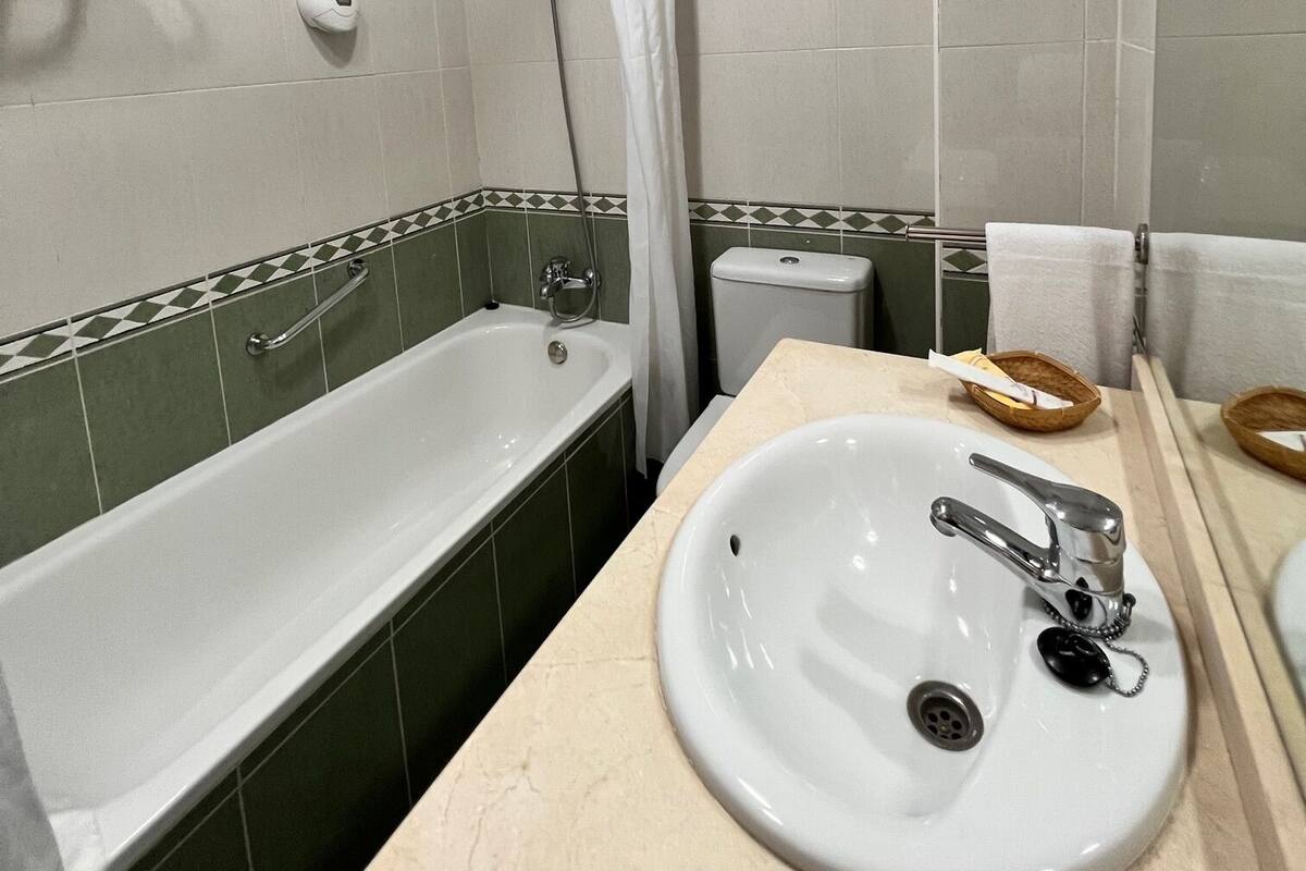A bathroom with a bathtub, a sink, and a toilet.