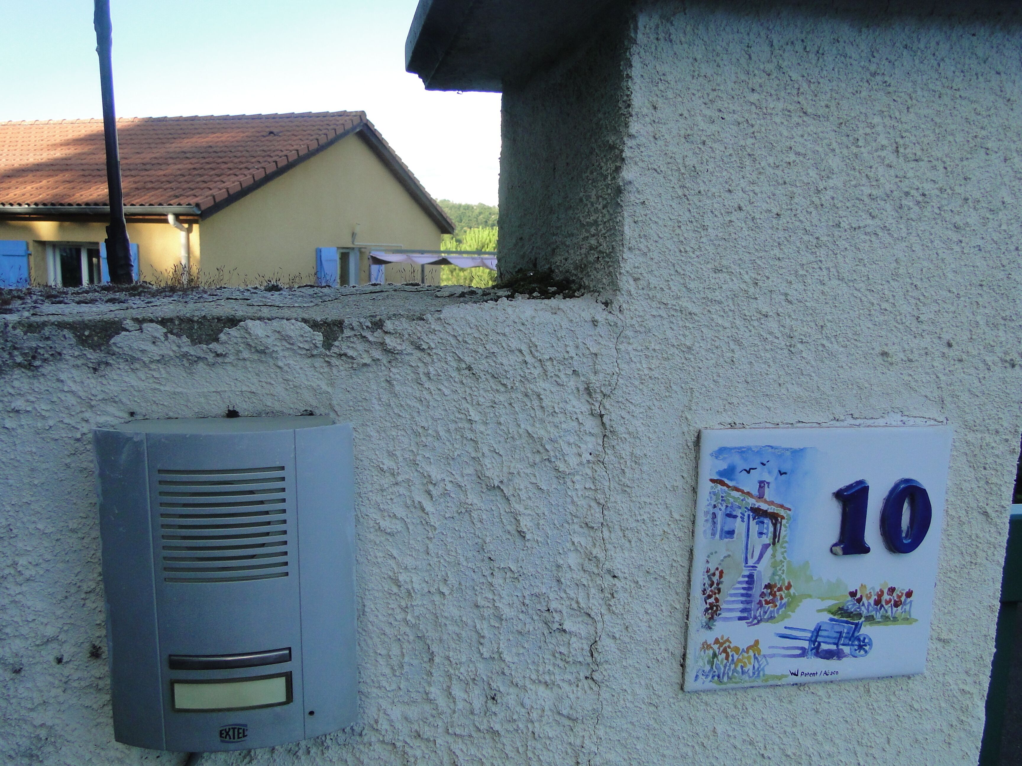 A building with a concrete exterior, a utility box, and a sign with the number 10.
