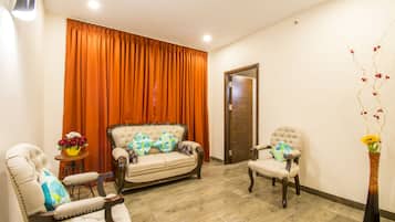 Deluxe Suite, Non Smoking | Living room | 32-inch LED TV with cable channels, TV