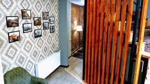 A room with patterned wallpaper, a radiator, a green armchair, and a wooden partition. - Old Town Mtatsminda (Tbilisi)