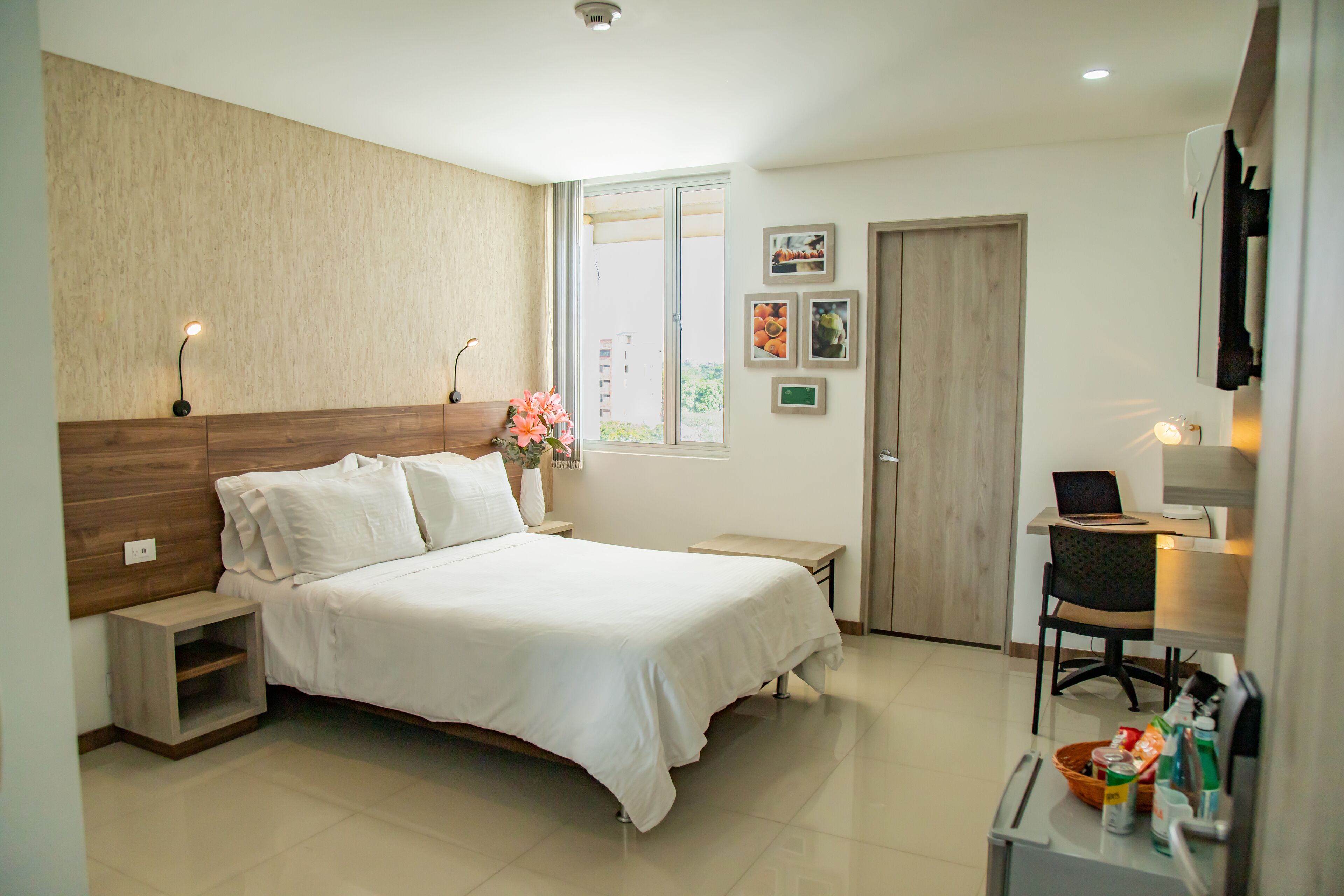 A bedroom with a bed, bedside tables, a desk, and a chair.