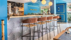 A bar area with a counter, stools, and hanging lights. - Hotel Estancia Chipichape Cali (Cali)