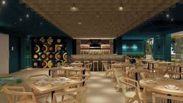 Restaurante com várias mesas e cadeiras, área de bar e parede com padrões circulares.