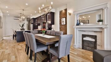 A modern kitchen with dark cabinets, a central island, and a chandelier.