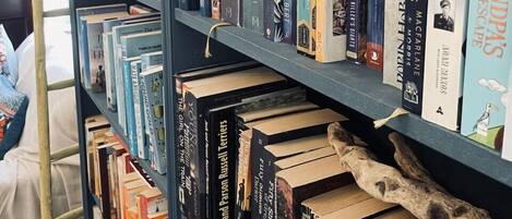 Una prestatgeria plena de llibres, alguns amb títols i autors visibles.