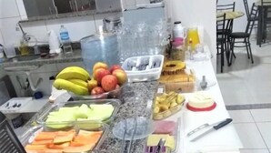 A buffet setup with various food items, including fruits, bread, and beverages.