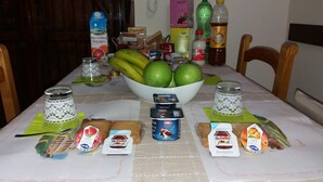 A dining table with a variety of food items, including fruits, condiments, and packaged goods. - M & I Apartment (Fiumicino)