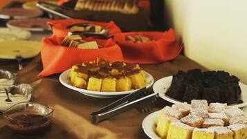 Una mesa de buffet con diversos postres y un pastel.