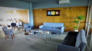 A modern lounge area with a blue sofa, armchairs, and a coffee table. - Hotel Terrapuerto (Valdivia)