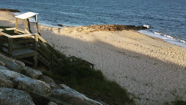 A wooden staircase leading to a beach with a clear view of the ocean. - Doryman Motel (Dennis Port)