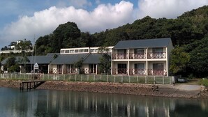 A waterfront hotel with multiple floors, balconies, and a view of the lake. - Tabist Villa Daioh Resort Iseshima (Shima)