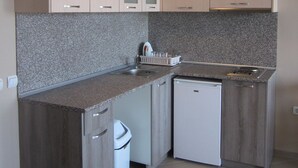 A compact kitchen with granite countertops, white cabinetry, and a built-in dishwasher. - Sunny Sands Studios (Burgas)