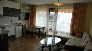 A compact living space with a kitchenette, dining area, and seating area. - Sunny Sands Studios (Burgas)