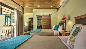 A modern hotel room with a large bed, a desk, and a kitchenette. - Villas Piña - Adults Only (Cahuita)
