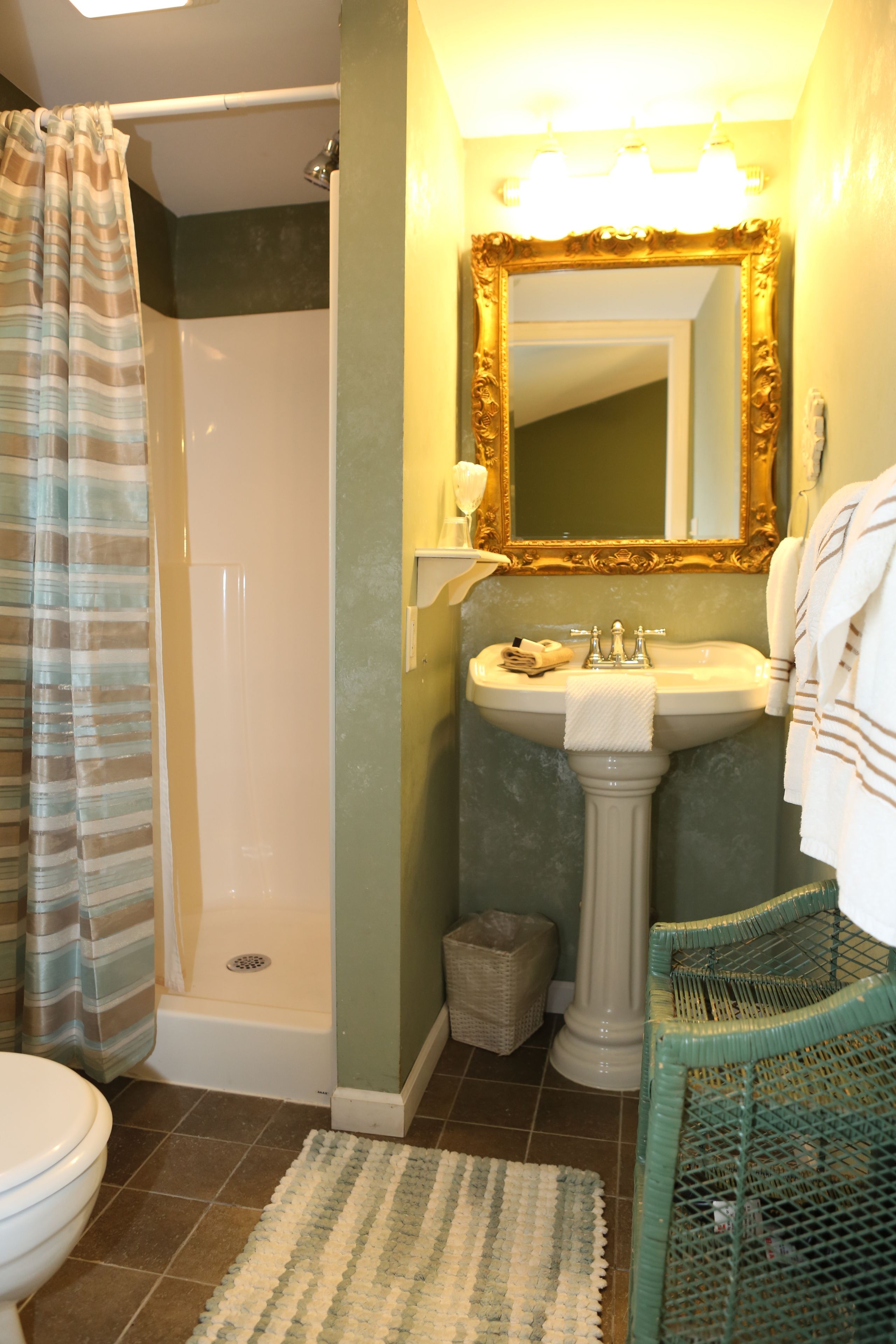 A bathroom with a shower, sink, and toilet.