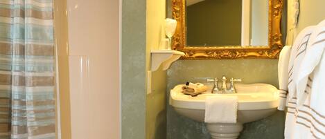 A bathroom with a shower, sink, and toilet.