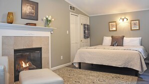 A bedroom with a fireplace, a bed, a nightstand, and a ceiling fan. - Martha's Vineyard Bed & Breakfast (South Haven)