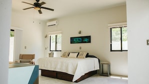 A bedroom with a bed, a ceiling fan, an air conditioning unit, a window, and a wall-mounted artwork. - Enjoy space and privacy Casa Roo by BRM (Tulum)
