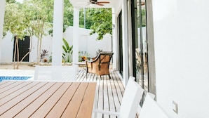 An outdoor patio with a wooden table and white chairs, a ceiling fan, and a hanging plant. - Enjoy space and privacy Casa Roo by BRM (Tulum)